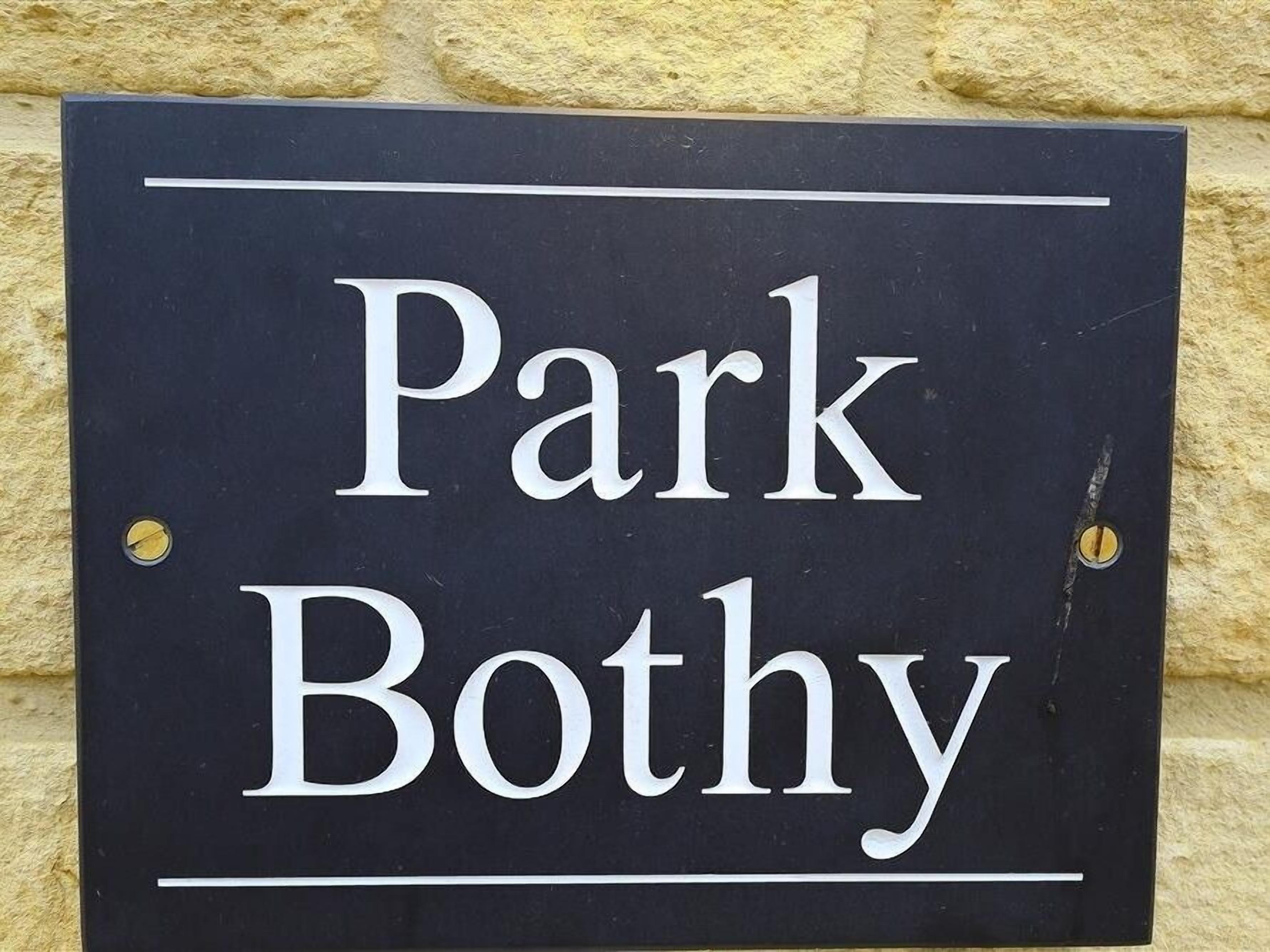 Ein Schild mit dem Schriftzug 'Park Bothy' an einer Wand befestigt.