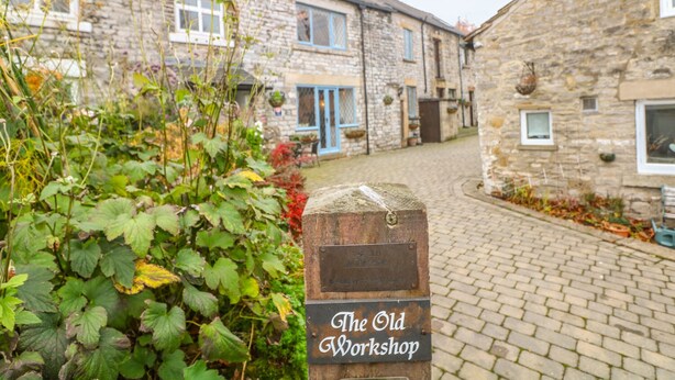 A stone building labeled "The Old Workshop" with a cobblestone path leading to it.