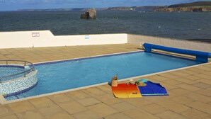 Une piscine avec vue sur la mer et les falaises.