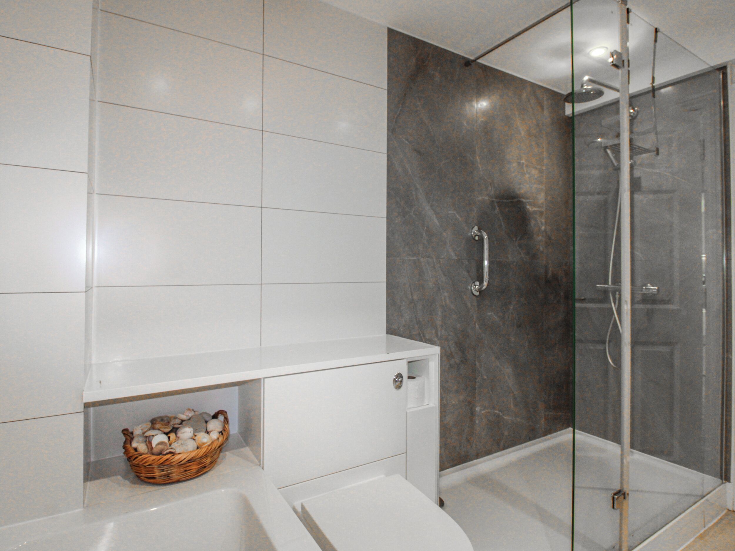 Un baño moderno con ducha, inodoro y lavamanos.