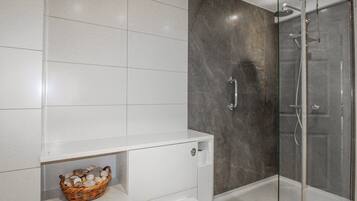 Un baño moderno con ducha, inodoro y lavamanos.
