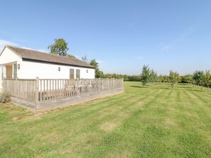 A white single-story house with a fenced patio and a well-maintained lawn. - The Clealings (Witney)