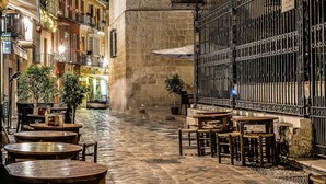A cobblestone street with outdoor seating, a stone building with a bell tower, and a wrought iron fence. - Very bright apartment in the historic center - MALAMA B2  (Málaga)