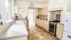 A spacious kitchen with granite countertops, a built-in oven, and a microwave.