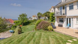A residential area with a well-maintained lawn, a boat, and a house with a balcony. - Grand View (Kingsbridge)
