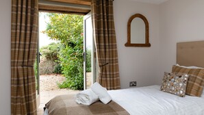 Une chambre à coucher avec un lit, un miroir et des rideaux.