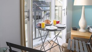 A balcony with breakfast items, a lamp, and a view of a town. - 44 Dart Marina (Dartmouth)
