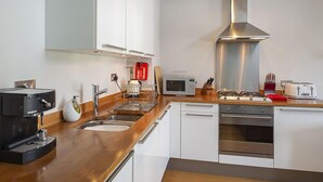 A modern kitchen with a stainless steel range hood, a built-in microwave, and a toaster. - 44 Dart Marina (Dartmouth)
