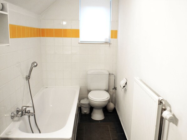 A small, white bathroom with a bathtub, toilet, and a window above the toilet. - B&B Le Clos du Lac (Jalhay)
