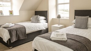 Une chambre avec deux lits, une table de chevet et une fenêtre donnant sur un beau paysage.