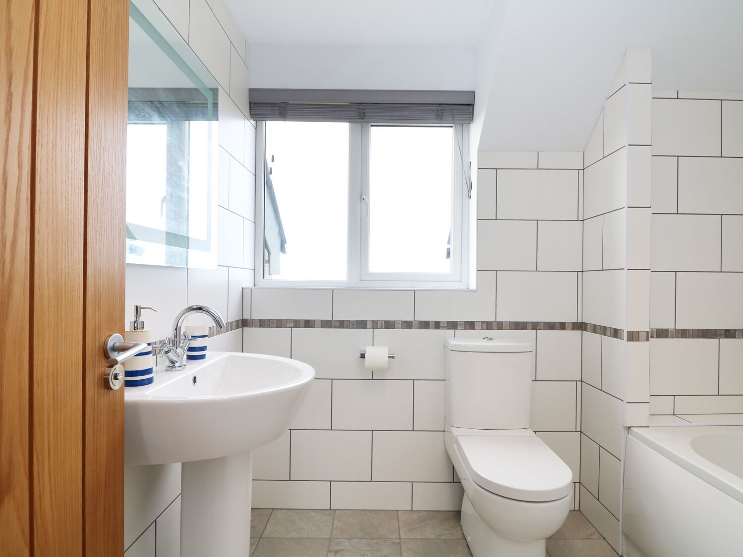 Un baño moderno con lavamanos, inodoro y bañera.
