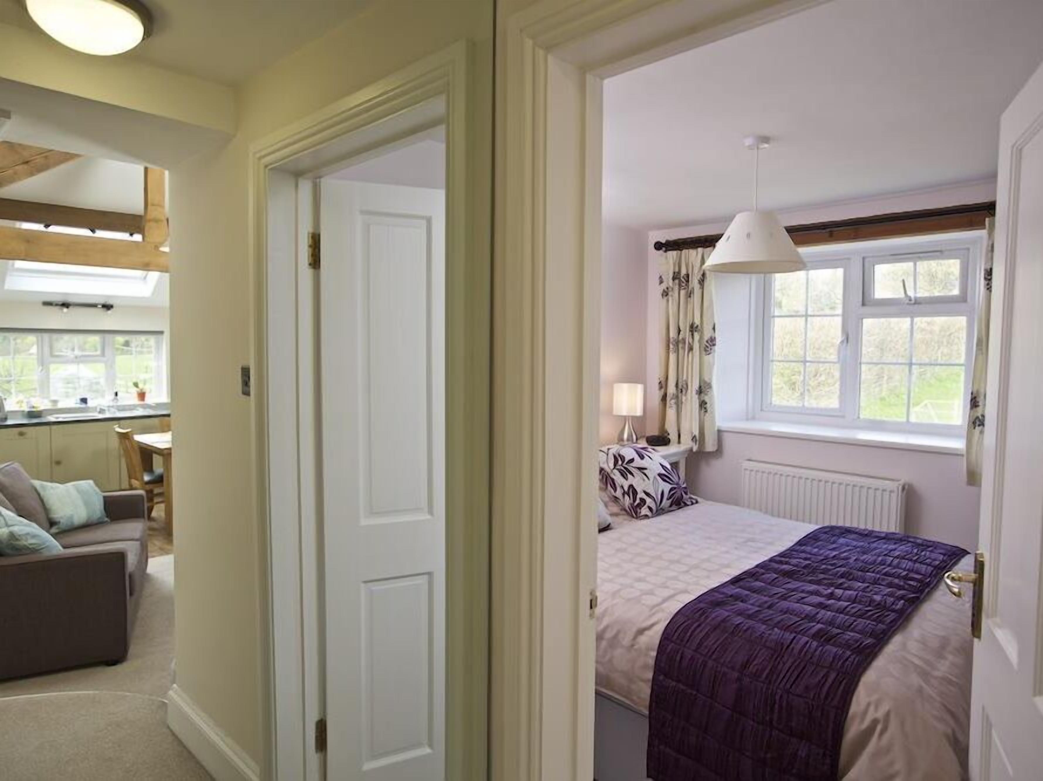 Une chambre à coucher avec un lit, une fenêtre avec des rideaux, un radiateur et une lampe de chevet.