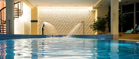Una piscina techada, sillones reclinables de piscina