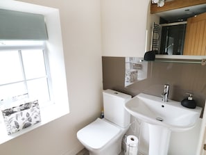 Ein Badezimmer mit Toilette, Waschbecken und Fenster.