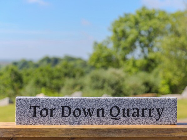 A granite plaque with the inscription "Tor Down Quarry" on a wooden surface. - Tressa, Tor Down Quarry (Bodmin)