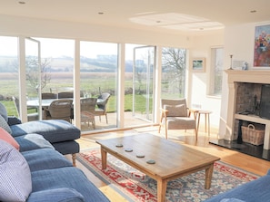 Relax in this spacious living room with a large, open-plan layout and scenic views from the balcony.