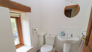 Un bagno piccolo e pulito con WC, lavandino e specchio.