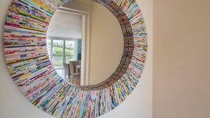 Un miroir rond doté d’un cadre coloré à rayures.