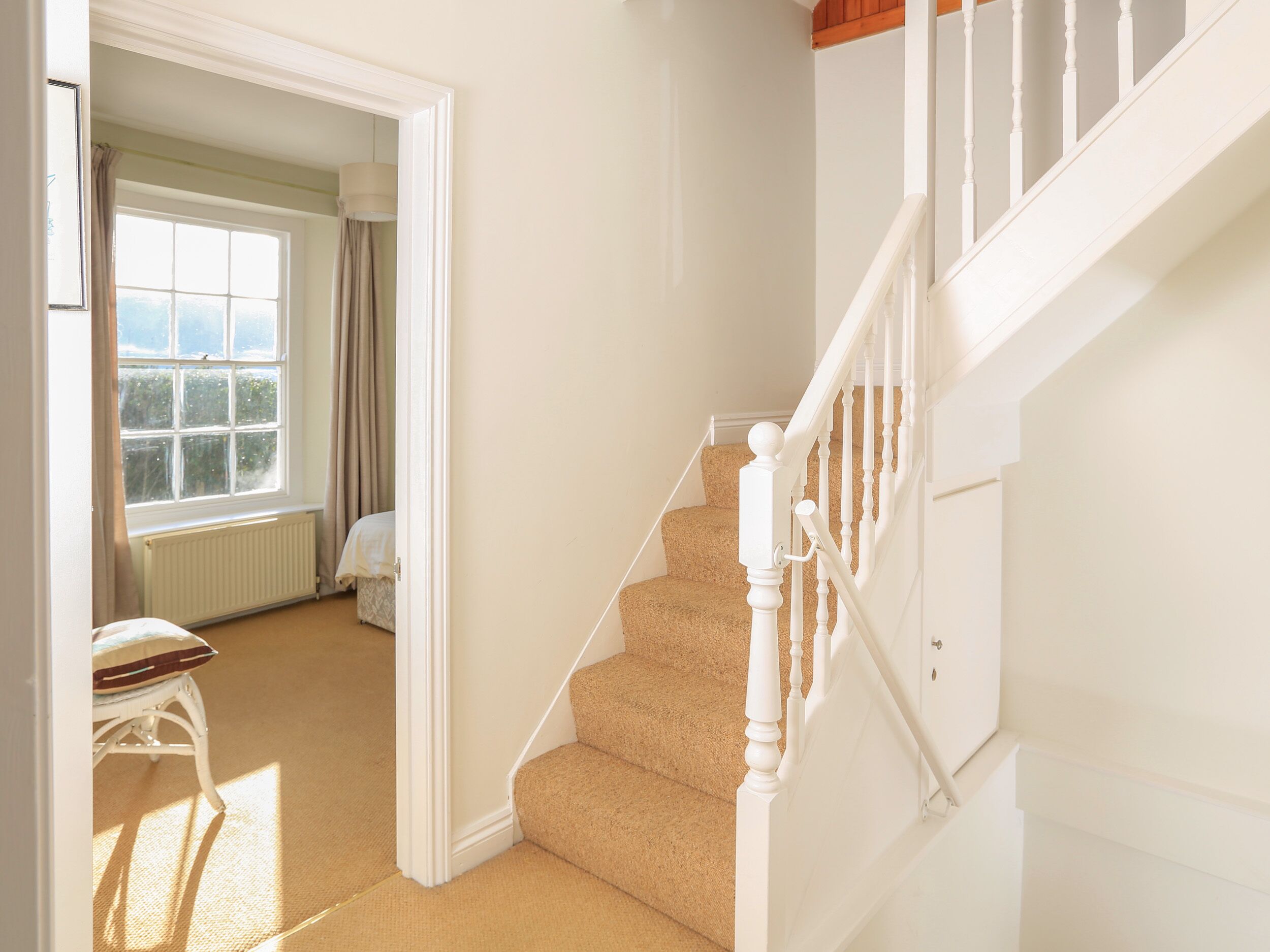 Un escalier avec des balustrades blanches menant à un palier.