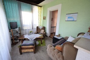 Apartamento standard, 1 quarto | Área de estar | TV de tela plana