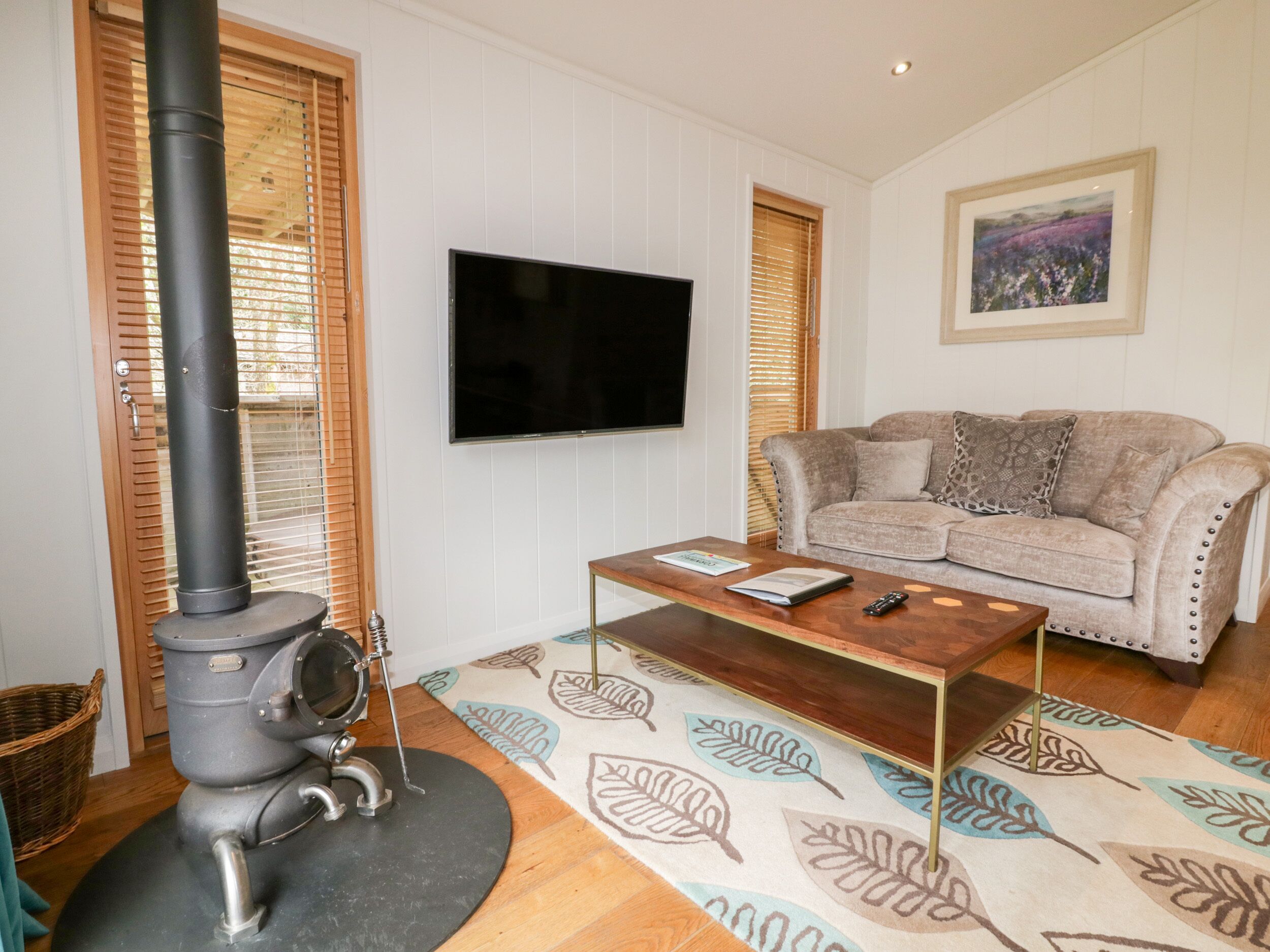 Una sala de estar con chimenea, un sofá, una mesa de centro y un televisor.