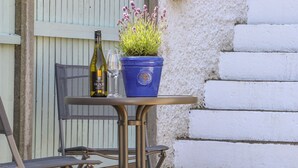 Una mesa con una botella de vino, una copa y una planta en maceta.