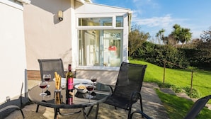 An outdoor patio with a table, chairs, and a bottle of wine. - Bankside (Kingsbridge)