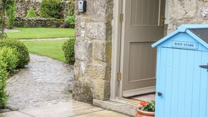 A stone building with a wooden door and a blue boot store sign. - The Bothy (Skipton)