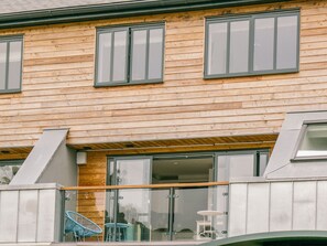 A wooden building with large windows and a balcony with chairs. - Sidings at Brunel Two (Lostwithiel)