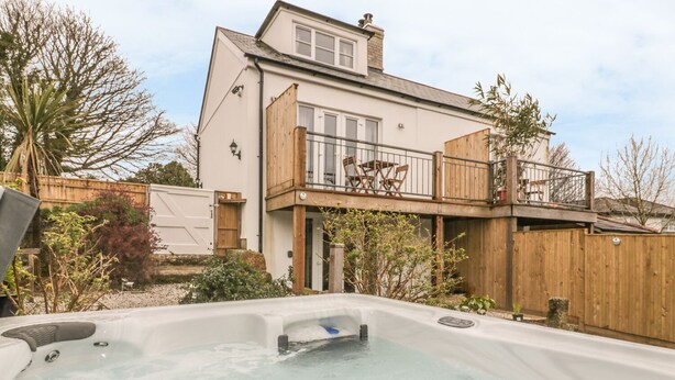 A two-story house with a hot tub in the backyard. - Crift Farm Cottage (Bodmin)