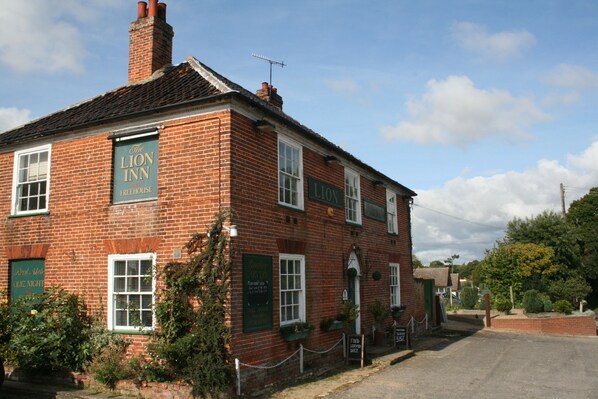 A traditional brick building with a sign reading "The Lion Inn Freehouse." - The Theberton Lion (Leiston)