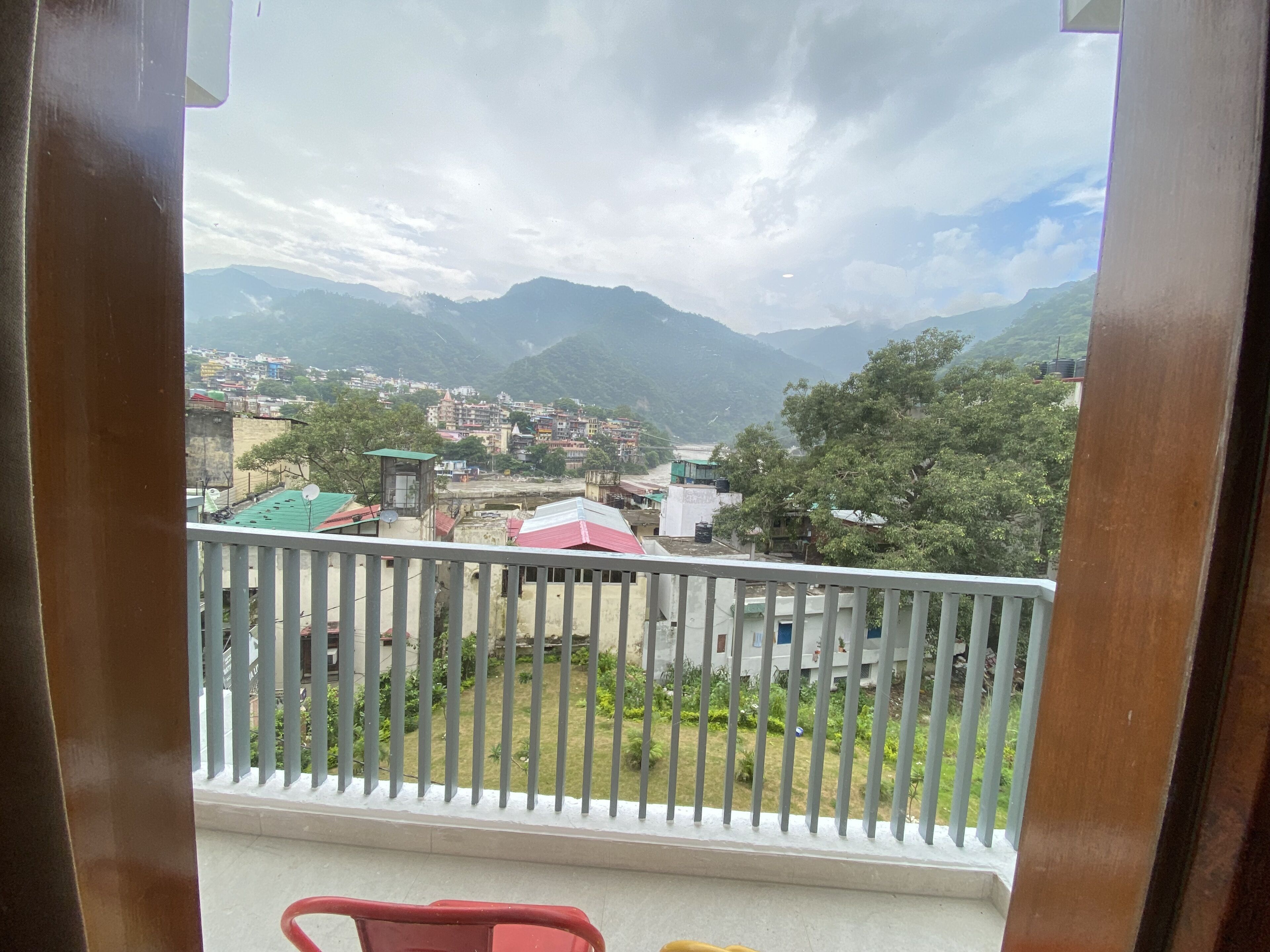 A balcony with a view of a town and mountains.