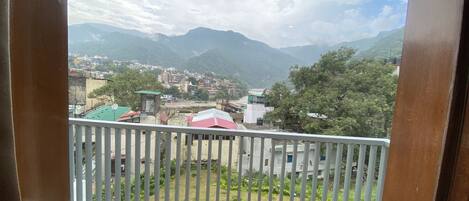 A balcony with a view of a town and mountains.