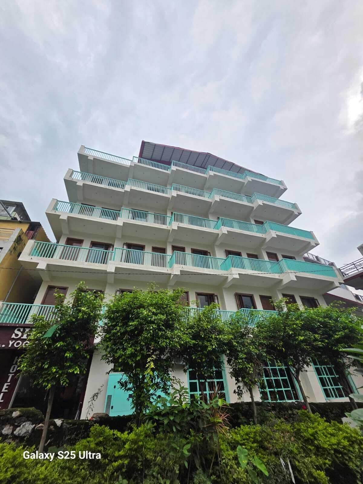 A multi-story building with balconies and a sign for a yoga studio.