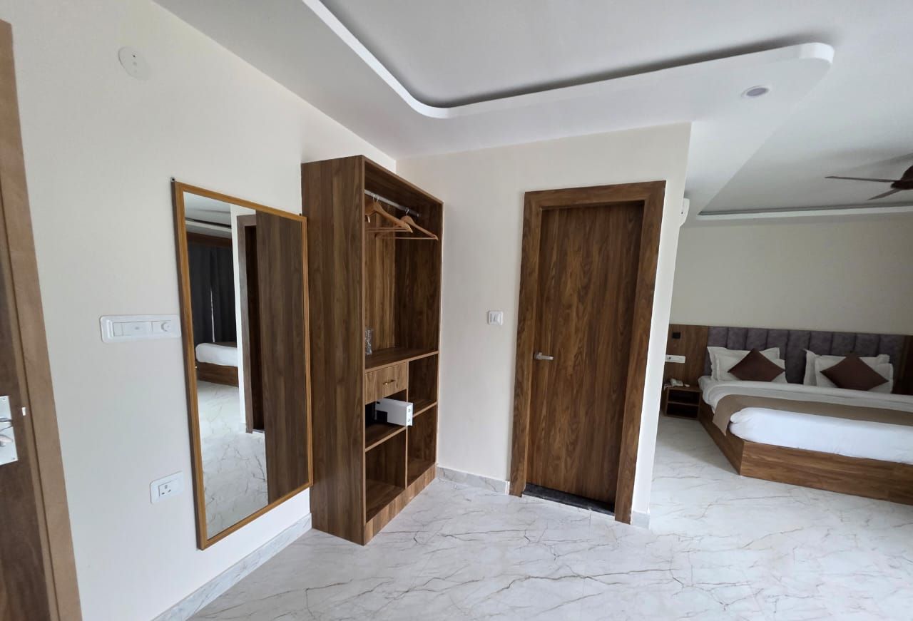 Una camera da letto con un grande specchio, un'armadiatura in legno e un letto con testiera.