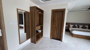 Un dormitorio con un espejo grande, un armario de madera y una cama con cabecera.
