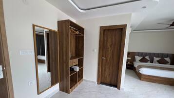 Una camera da letto con un grande specchio, un'armadiatura in legno e un letto con testiera.