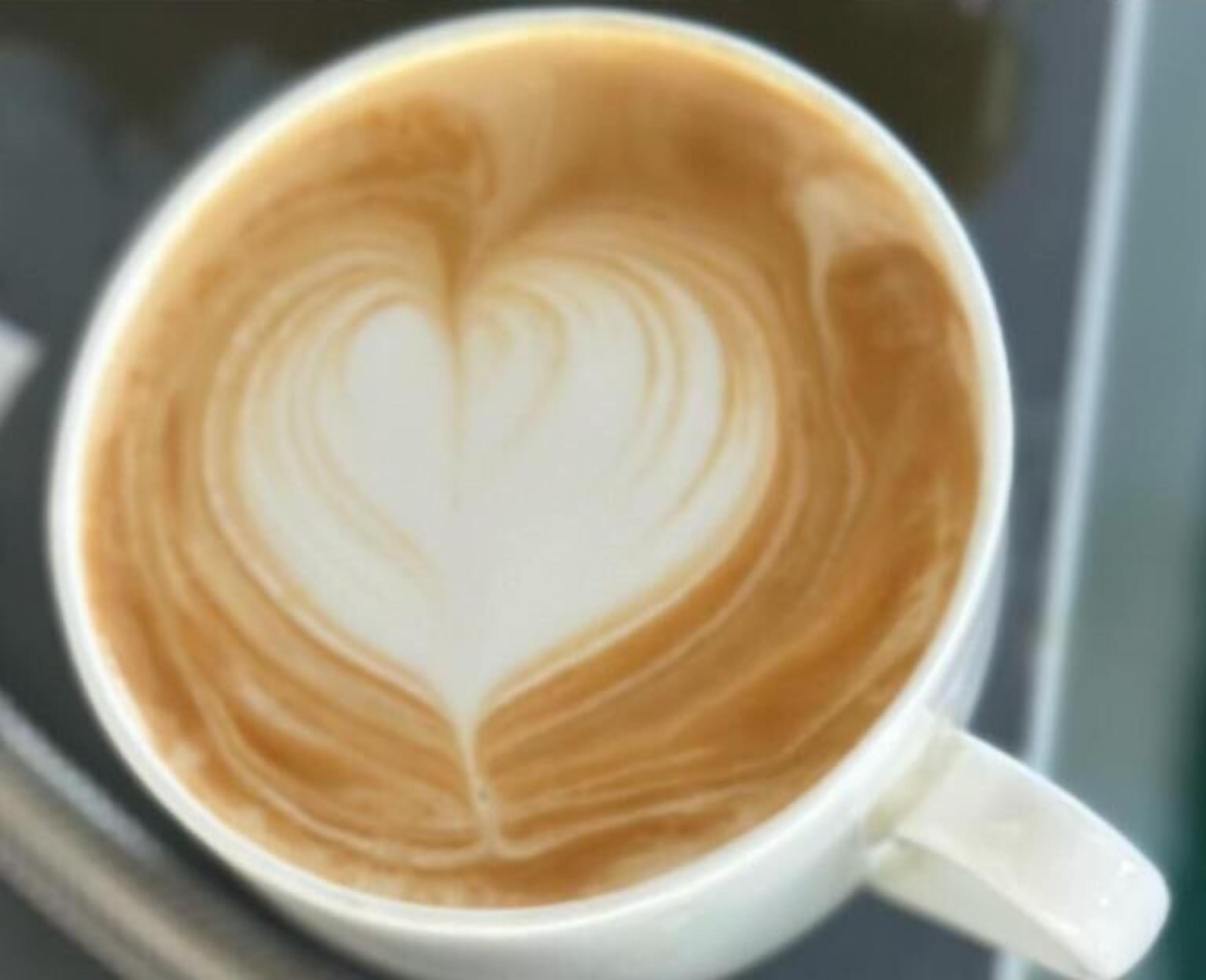 Een kop koffie met een hartje in de latte-kunst op het oppervlak.