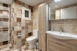 A bathroom with a toilet, sink, and towel rack. - Brand New Modern Flat in the Heart of the City (Thessaloniki)