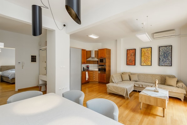 Un appartement moderne comprenant un salon, une cuisine et une chambre.