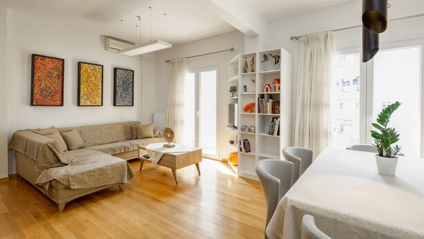 A modern living room with a sofa, coffee table, and a bookshelf.