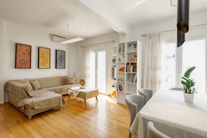 A modern living room with a sofa, coffee table, and a bookshelf. - Brand New Modern Flat in the Heart of the City (Thessaloniki)
