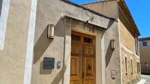 Un edificio con una gran puerta doble de madera, un letrero que dice “la cour carrée” y una ventana pequeña con una lámpara.