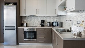 A modern kitchen with stainless steel appliances, a microwave, a coffee maker, and a sink. - Bright Modern Flat next to Beach (Platanias)