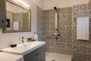 A modern bathroom with a large mirror, a sink, and a shower. - Bright Modern Flat next to Beach (Platanias)