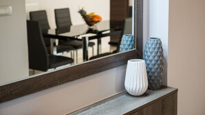 A mirror reflecting a dining area with chairs and a fruit bowl. - Bright Modern Flat next to Beach (Platanias)