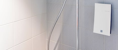 Ducha moderna con cabezal cuadrado y ducha de mano.