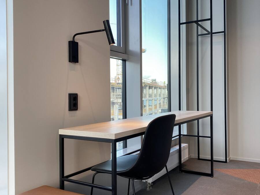 A modern office space with a desk, chair, and bench.