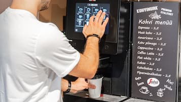 A person operating a coffee machine with a menu display.