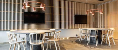 A modern conference room with a round table, six chairs, and two pendant lights.